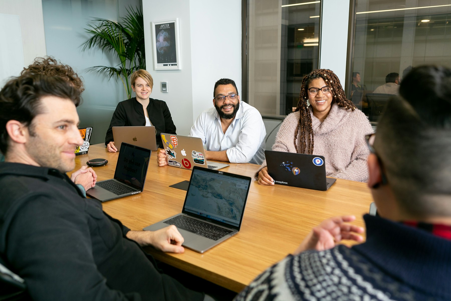 Equipo trabajando con portátiles en una reunión